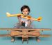 front-view-little-boy-playing-with-toy-planes-on-the-blue-floor